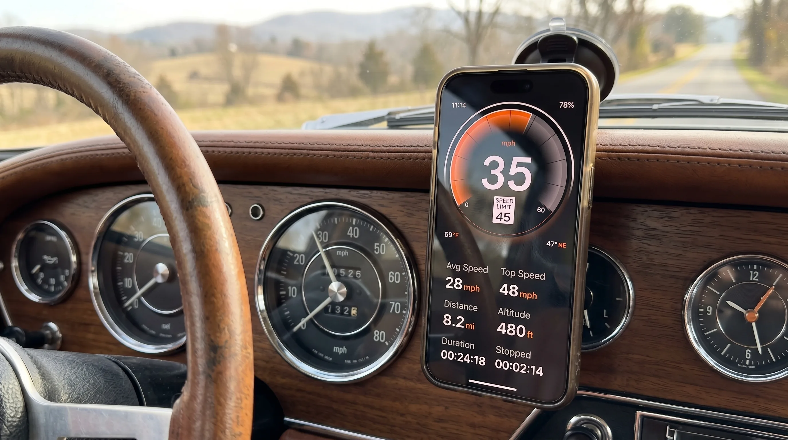 Ein Oldtimer-Armaturenbrett mit verchromten Einfassungen und analogem Tachometer, daneben ein modernes iPhone mit GPS Speedometer, das die tatsächliche Geschwindigkeit anzeigt