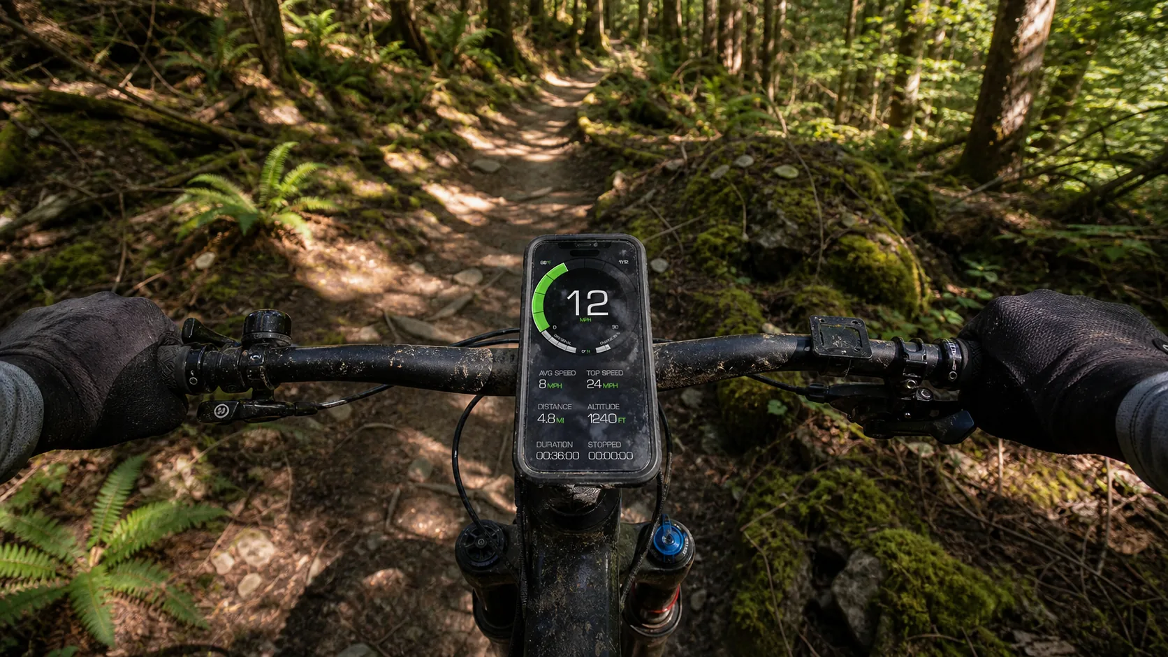 GPS Speedometer running on an iPhone in a rugged case on a mountain bike's stem mount, dappled forest trail extending ahead
